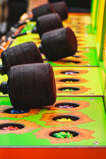An arcade whack-a-mole game, symbolizing the endless list of features popping up.