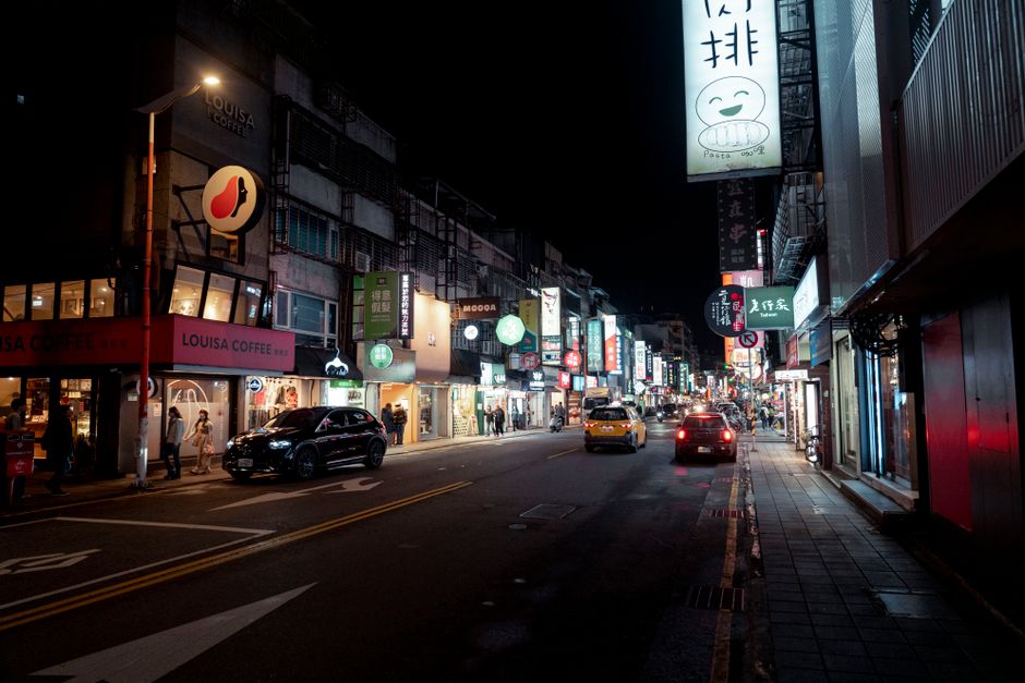 霓虹灯招牌，带有反光效果和艺术字设计，展示在夜晚的街道上。