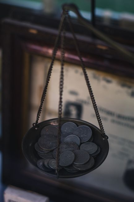 天平一边是金币（成本），一边是效率或代码图标，展示性价比的平衡